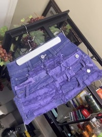 a purple ruffled skirt hanging on a rack