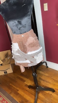 a mannequin with a skirt on a mannequin stand